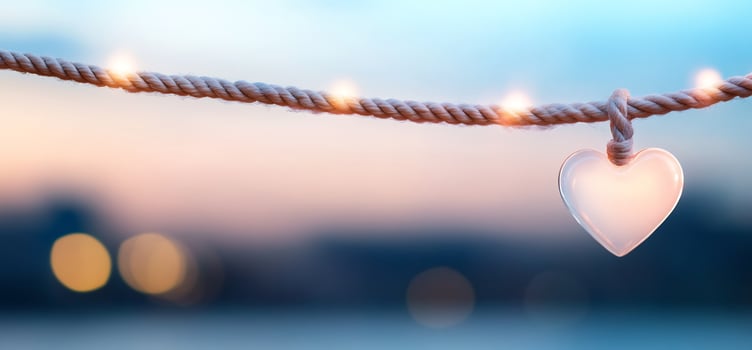 Heart on string lights at sunset, bokeh background. Romantic card photo