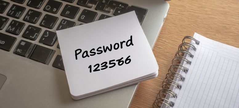 The notepad with handwritten password resting on laptop keyboard beside spiral notebook photo