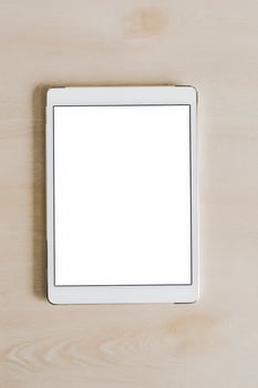Tablet lying on a wooden surface ready for use, showcasing a blank screen with minimal distractions photo