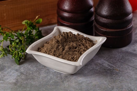 A bowl of brown powder next to a bottle of red wine photo