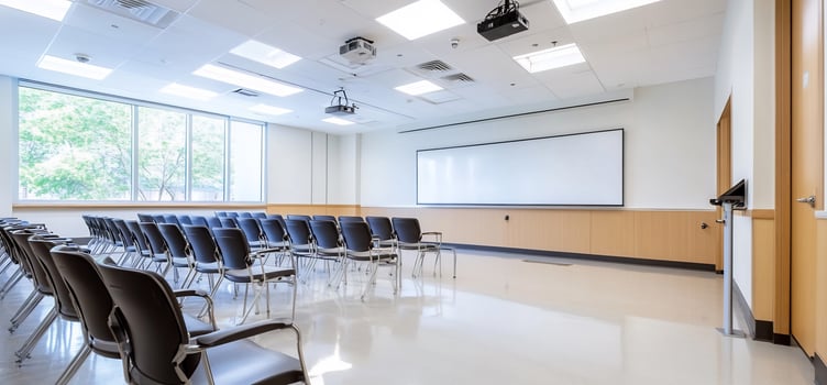 Empty classroom, chairs arranged, whiteboard, trees outside. Education setting photo