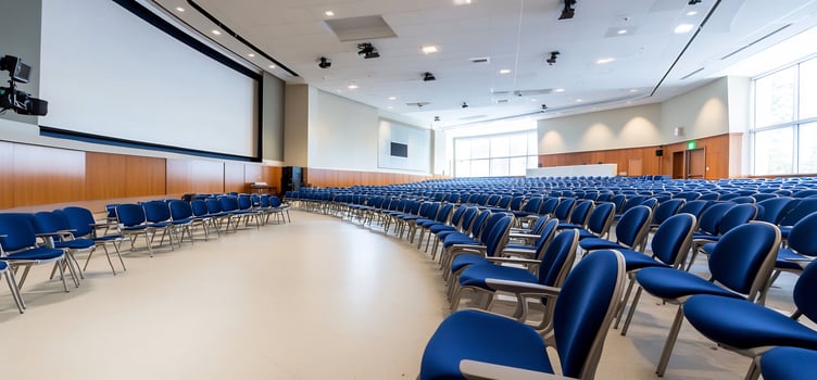 Empty lecture hall rows of blue chairs large screen presentation photo
