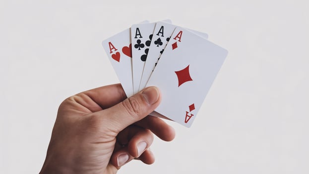 A hand holding four ace playing cards, showcasing a winning poker hand. photo