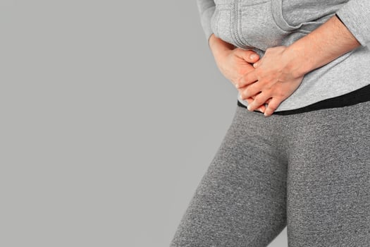 Pain in the abdomen of a European woman isolated on grey background photo