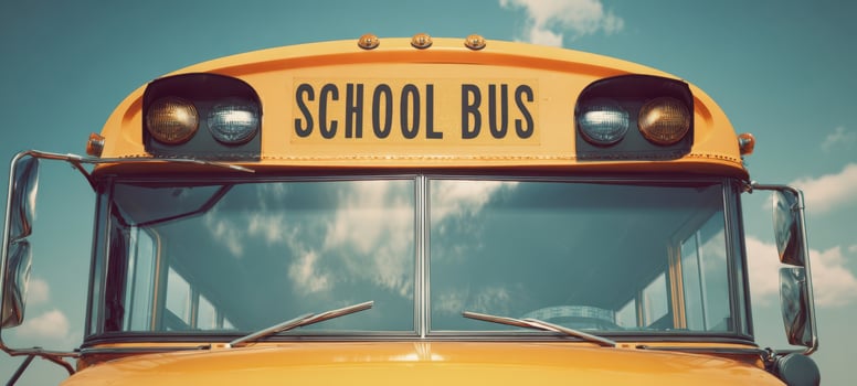 The school bus front view with retro headlights and reflective windows under sky photo