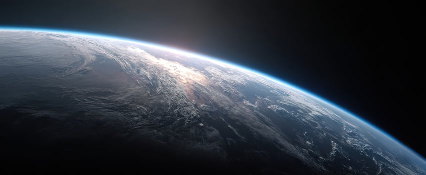 The Earth seen from space at sunrise with glowing atmosphere and cloud covered surface photo
