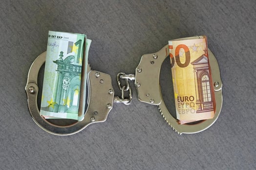 Handcuffs and euro money on table. Financial crime, dirty money and corruption concept. Tax offense concept. photo