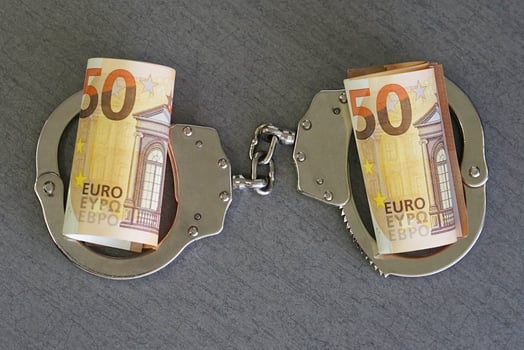 Handcuffs and euro money on tableFinancial crime, dirty money and corruption concept photo
