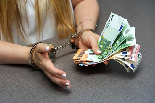 Criminal female hands locked in handcuffs at the workplace in office, bribe photo