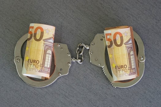 Handcuffs and euro money on tableFinancial crime, dirty money and corruption concept. Tax offense concept. photo