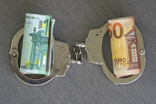 Handcuffs and euro money on table Financial crime, dirty money and corruption concept. Tax offense concept. photo