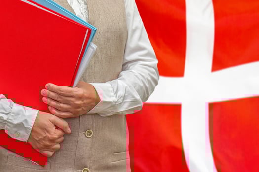 Woman's hands holding documents against Denmark flag background. Education abroad photo