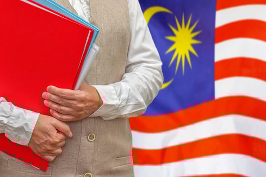 Woman's hands holding documents against Malaysia flag background. Education abroad photo