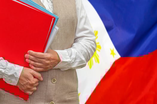 Woman's hands holding documents against Philippines flag background. Education abroad photo