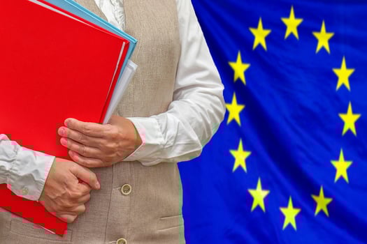 Woman's hands holding documents against EU flag background. Education abroad photo