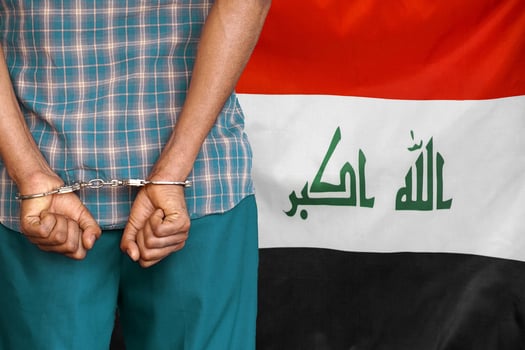 Arabian hands man with handcuffs on the background of the Iraq flag photo
