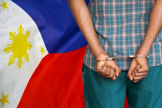 Black man with handcuffs on the background of the Philippines flag photo