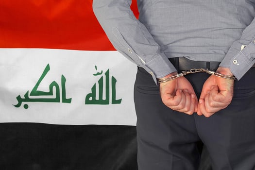 Arabian hands Male with handcuffs on the background of the Iraq flag photo
