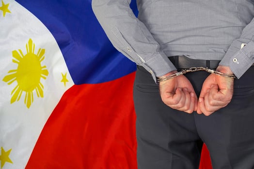 Male with handcuffs on the background of the Philippines flag photo