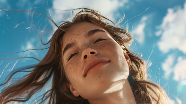 Youthful person against sky with wind blowing hair photo
