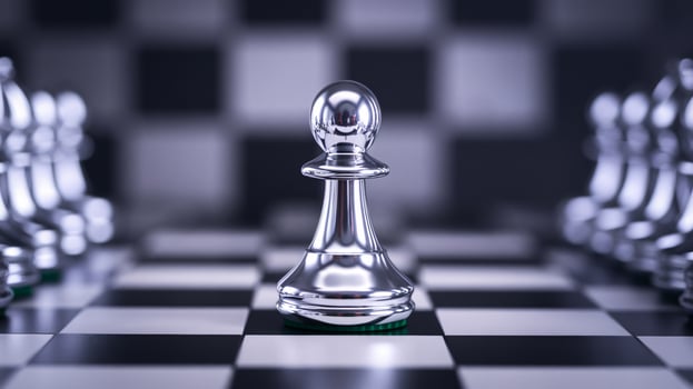 A shiny silver pawn stands at the center of a chessboard, symbolizing strategy and competition. photo