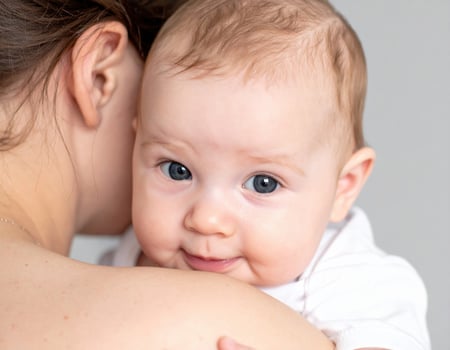 Closeup captures tender gaze of baby, eyes wide with fascination, showcasing moment of pure joy and connection photo