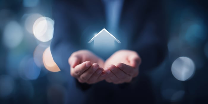 The Hands Holding a Home Icon Symbolizing Real Estate Investment and Security photo