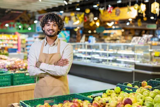 Grocery store employee with fresh produce photo