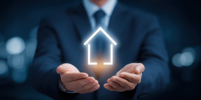 The professional holding a glowing house symbol representing real estate success. photo