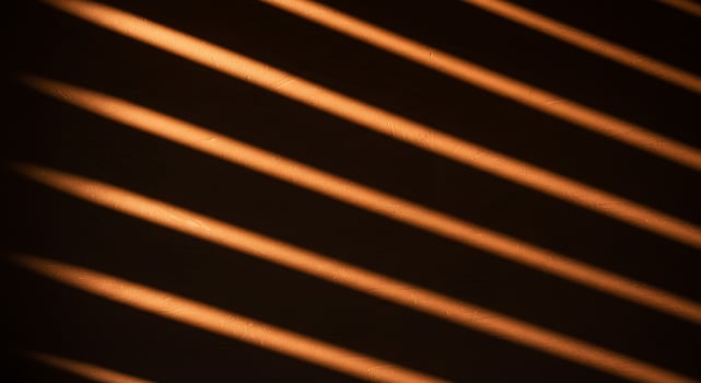 Sunlight on the wall of a room with wooden blinds photo