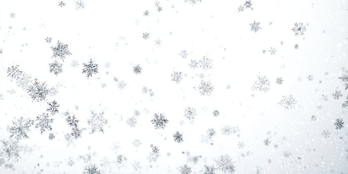 The delicate snowflakes falling against a serene white background. photo