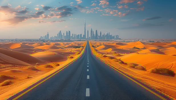 Road through desert landscape towards distant city skyline photo