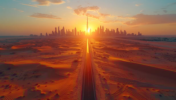 Desert road leading to city skyline at sunset photo