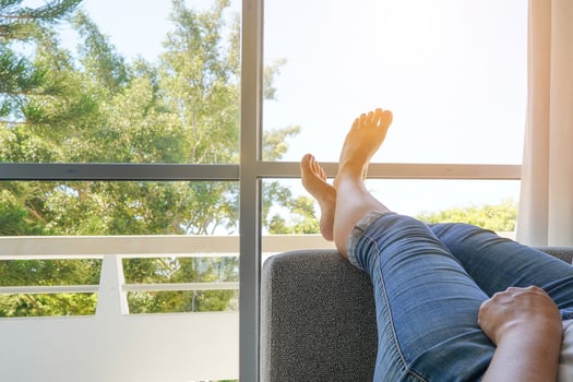 Young woman lying on the bed with raised legs up against the windows photo