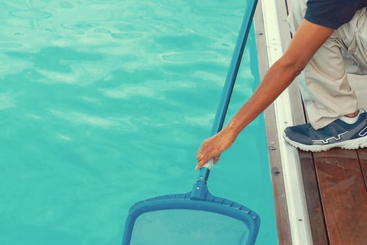 Hotel employee worker cleaning the pool photo