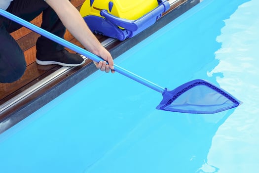 Hotel man staff worker cleaning the pool photo