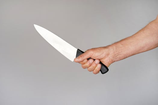 Kitchen knife in a hand isoleted on gray background photo