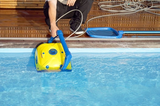 Caucasian staff worker cleaning the pool photo