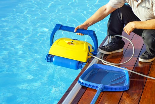 Hotel staff worker holds a pool cleaning robot photo