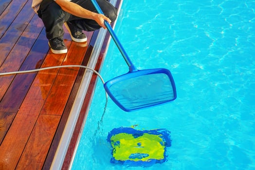 Hotel staff worker cleaning the pool of motel photo