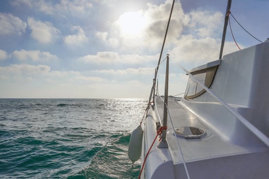 Sailboat bow with the tightened sail, sailing in the wind, with the sea in the background. Concept of water tourism. Sailing a yacht. photo