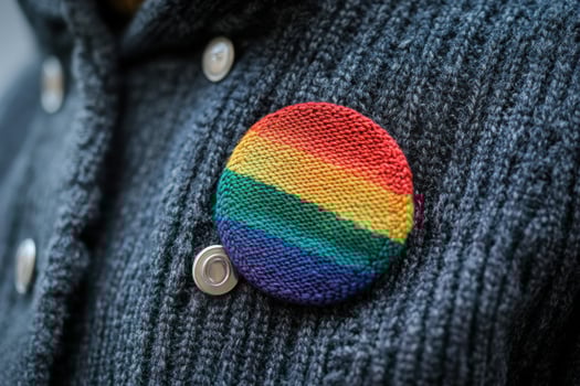 A person wearing a rainbow colored button photo