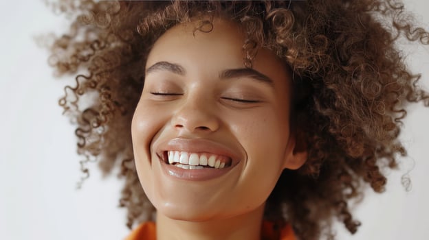 Smiling woman with curly hair closed eyes in radiant joy beauty portrait photo