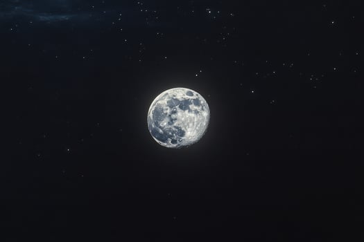 The moon is seen in the dark sky with stars photo