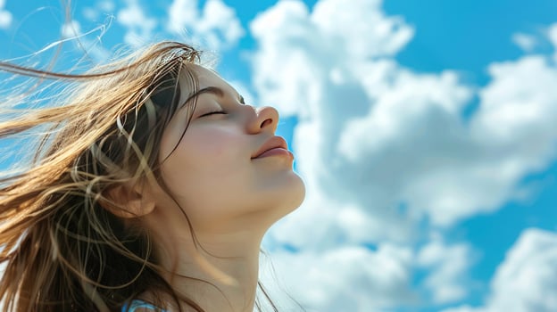 Woman faces the sky to breathe the fresh air and feel the breeze in her hair on a sunny day photo