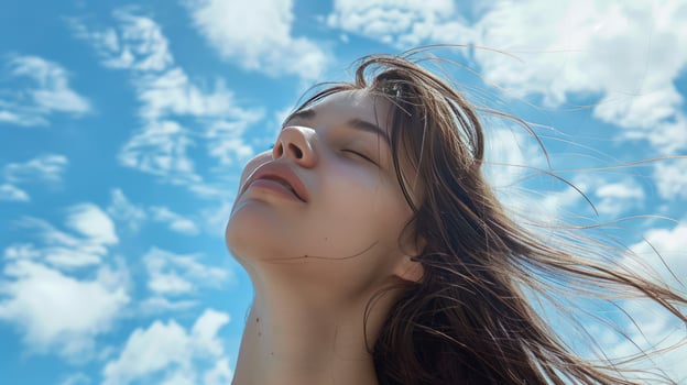 Woman relaxing in sunlight with blue sky and clouds feeling serene photo
