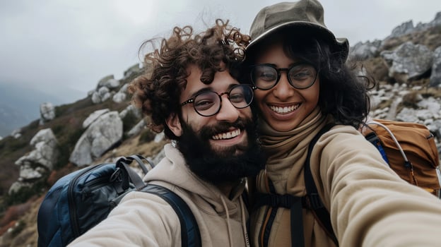 Smiling couple taking a selfie during a mountain hike adventure photo