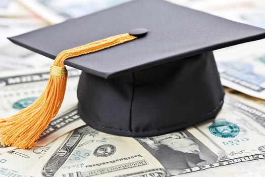 Graduation cap on money education costs photo