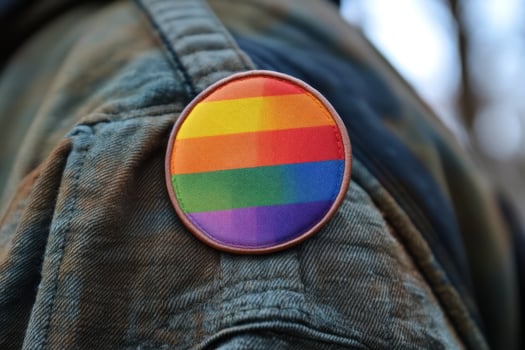 A rainbow colored badge on a person's jacket photo