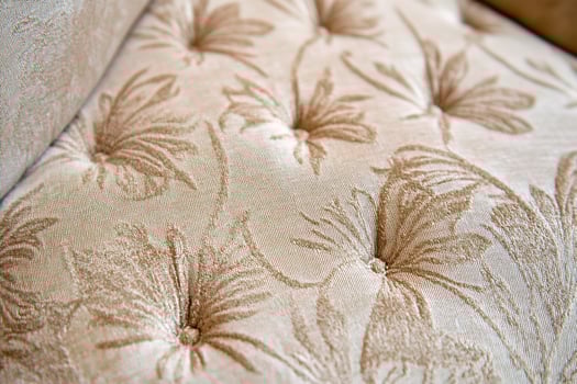Beige tufted fabric sofa detail. Interior design texture photo